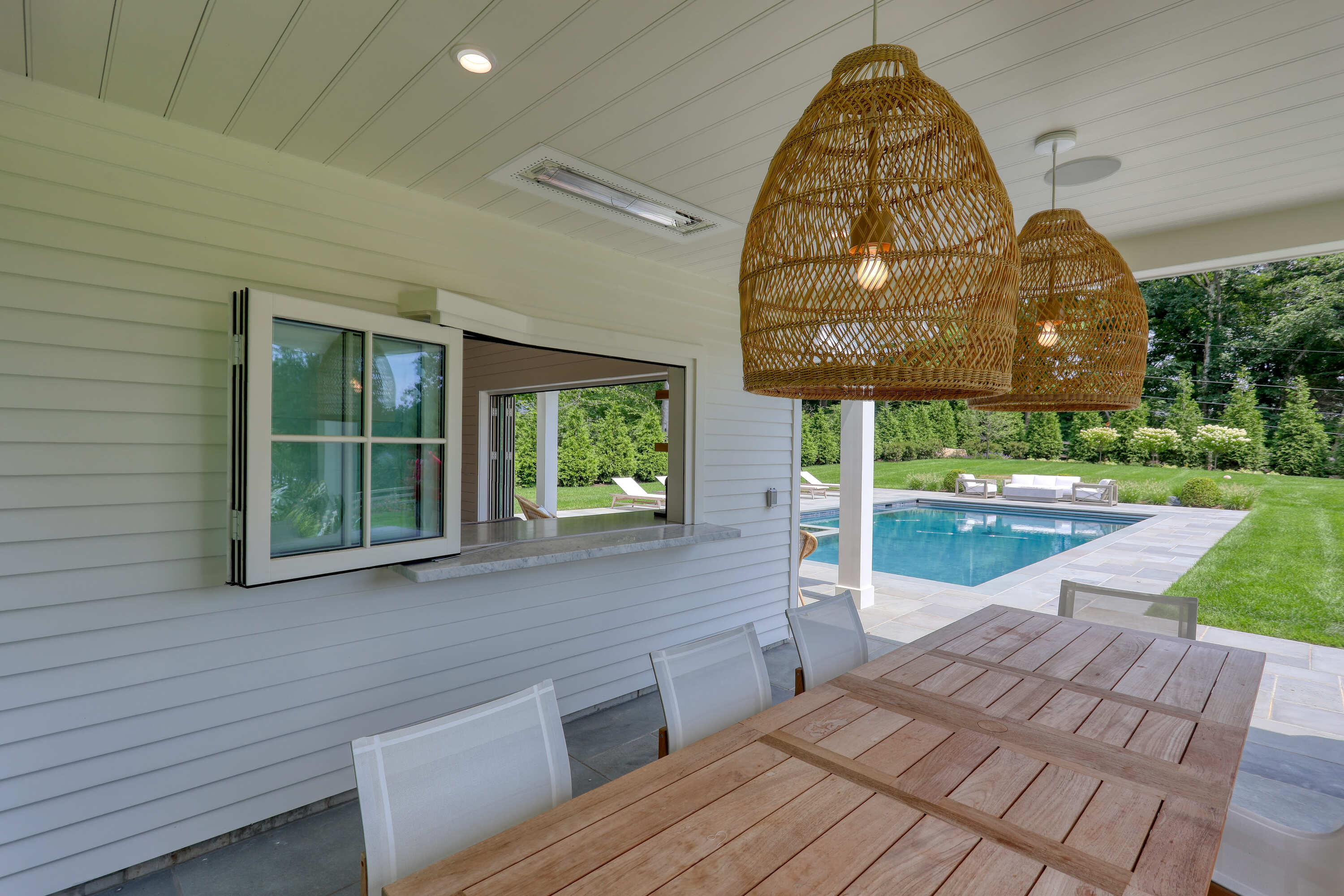 outdoor bar area with table and lights by Raymond Design Builders in Fairfield County, CT