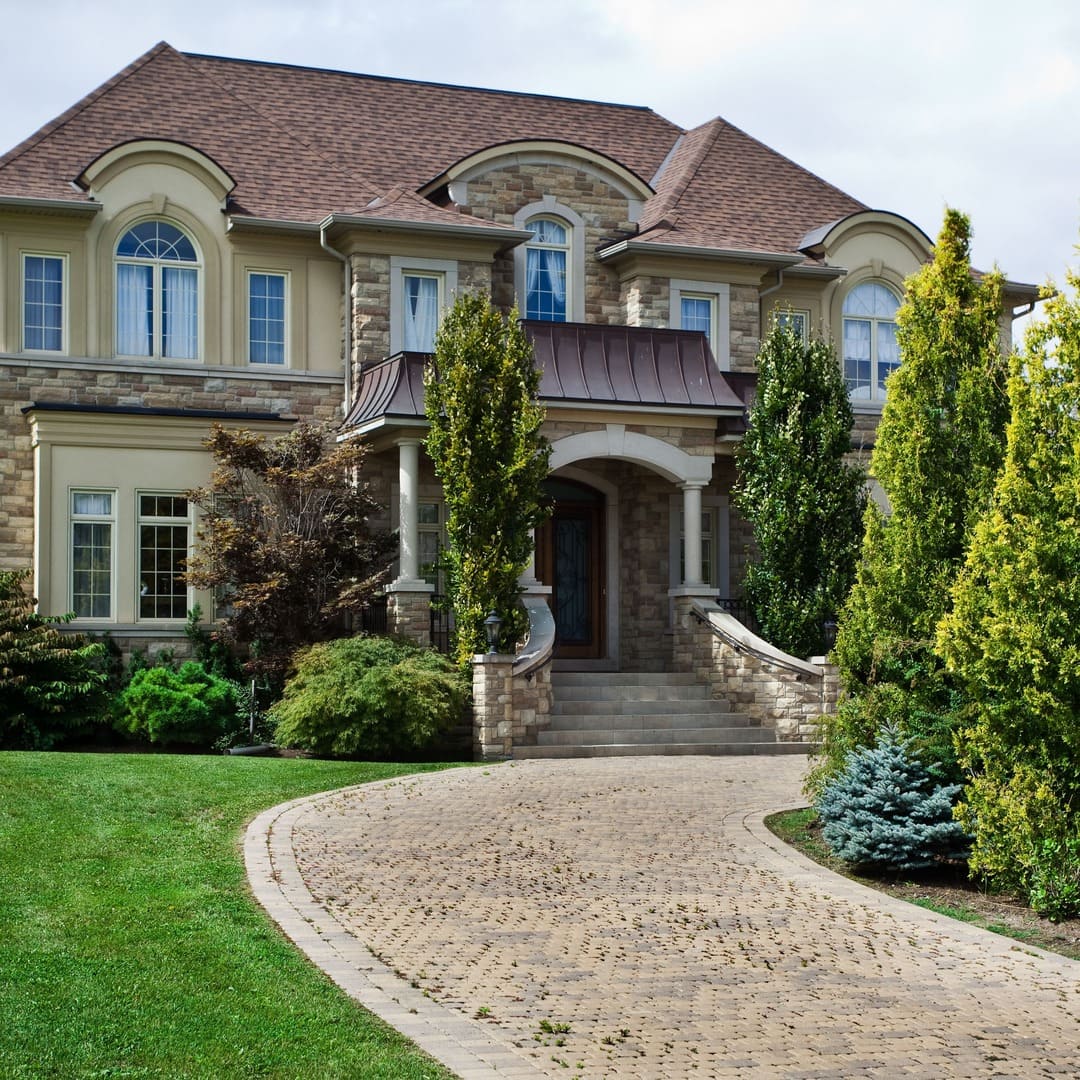 custom brick home with large round driveway by Raymond Design Builders