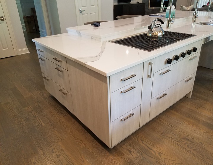 white island with grey cabinets and built in stovetop in Fairfield County Connecticut by Raymond Design Builders