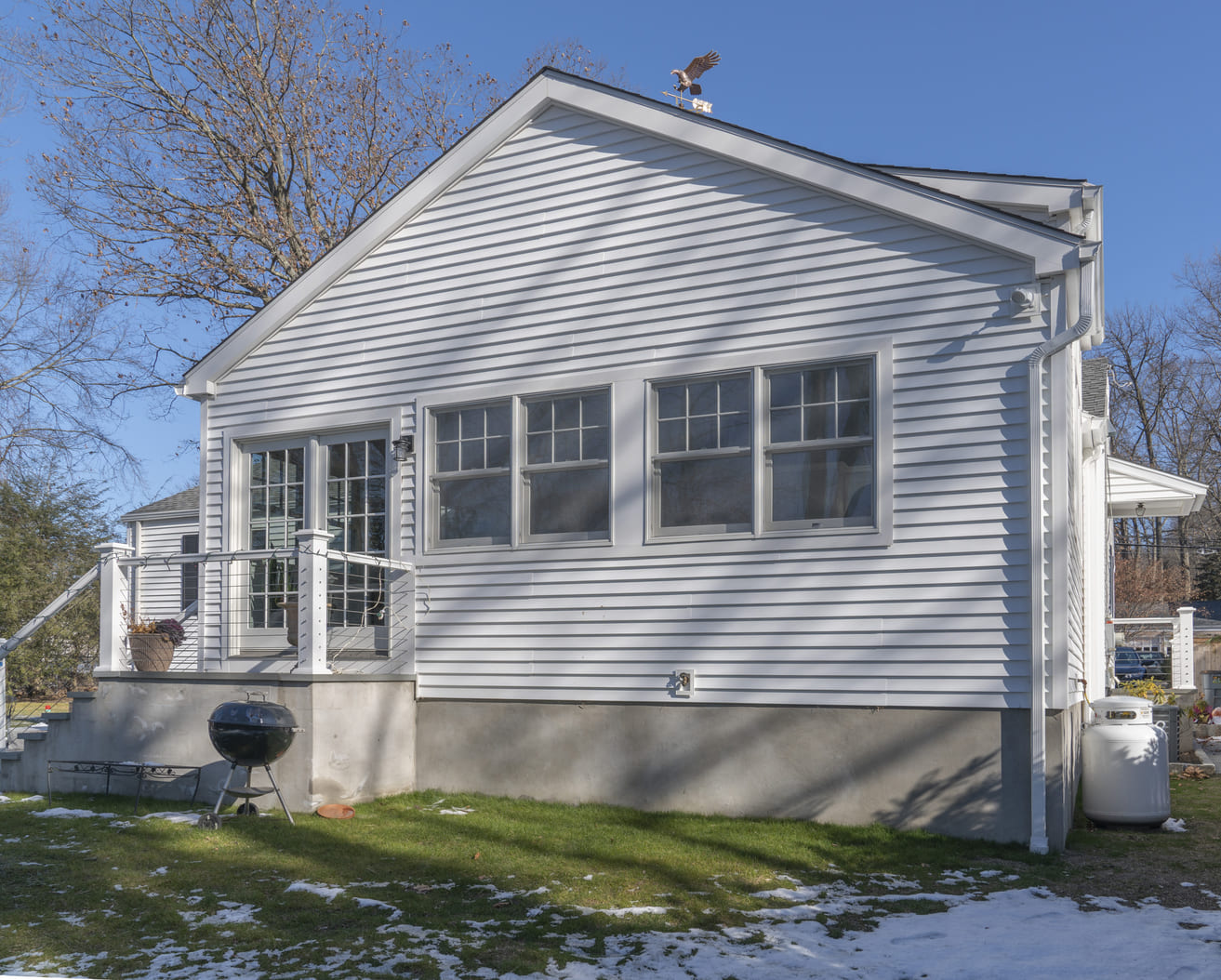 full white exterior back of home with back door and large windows by raymond design builders