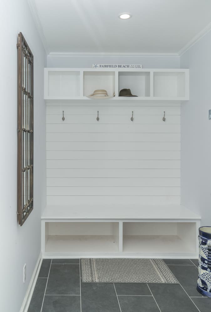 mudroom with white built in shoe  rack by raymond design builders