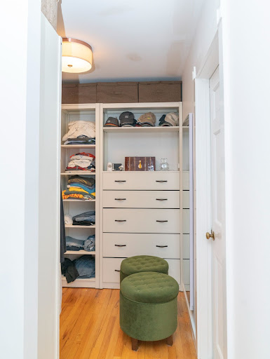 large closet with built in shelvning and green round chairs by raymond design builders