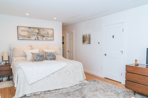 white bedroom with white comfortor by raymond design builders