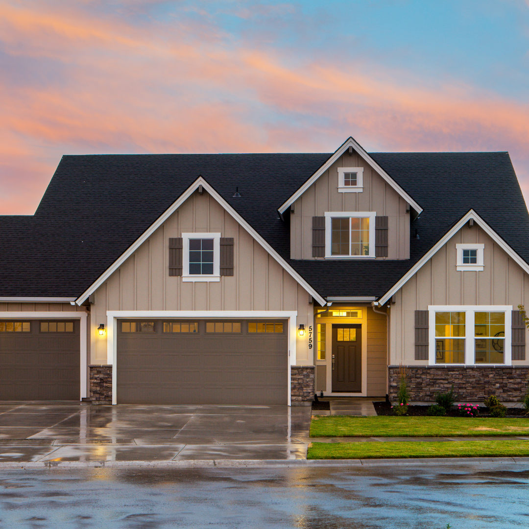 tan house with brown garage door and sunset background