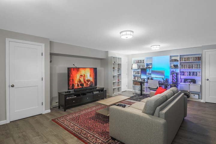 interior of home with couch, tv, and pc exterior of grey home home with addition by Raymond Design Builders in Fairfield County, CT