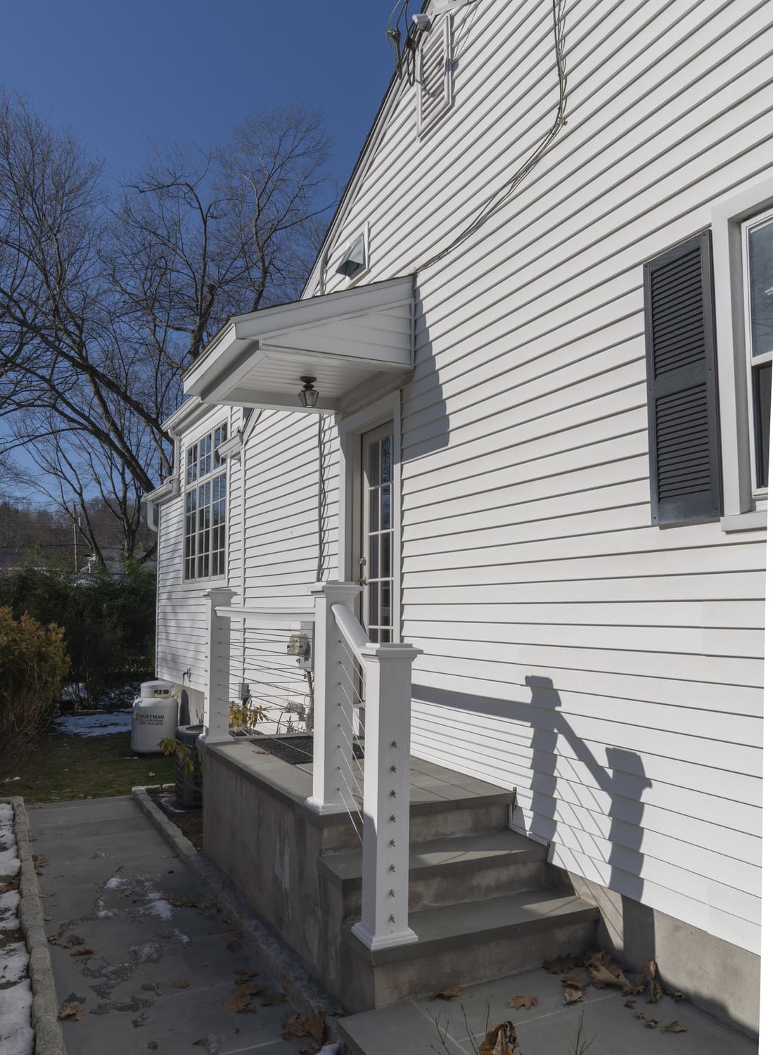 white exterior back exit with close up of back door and overhang by raymond design builders