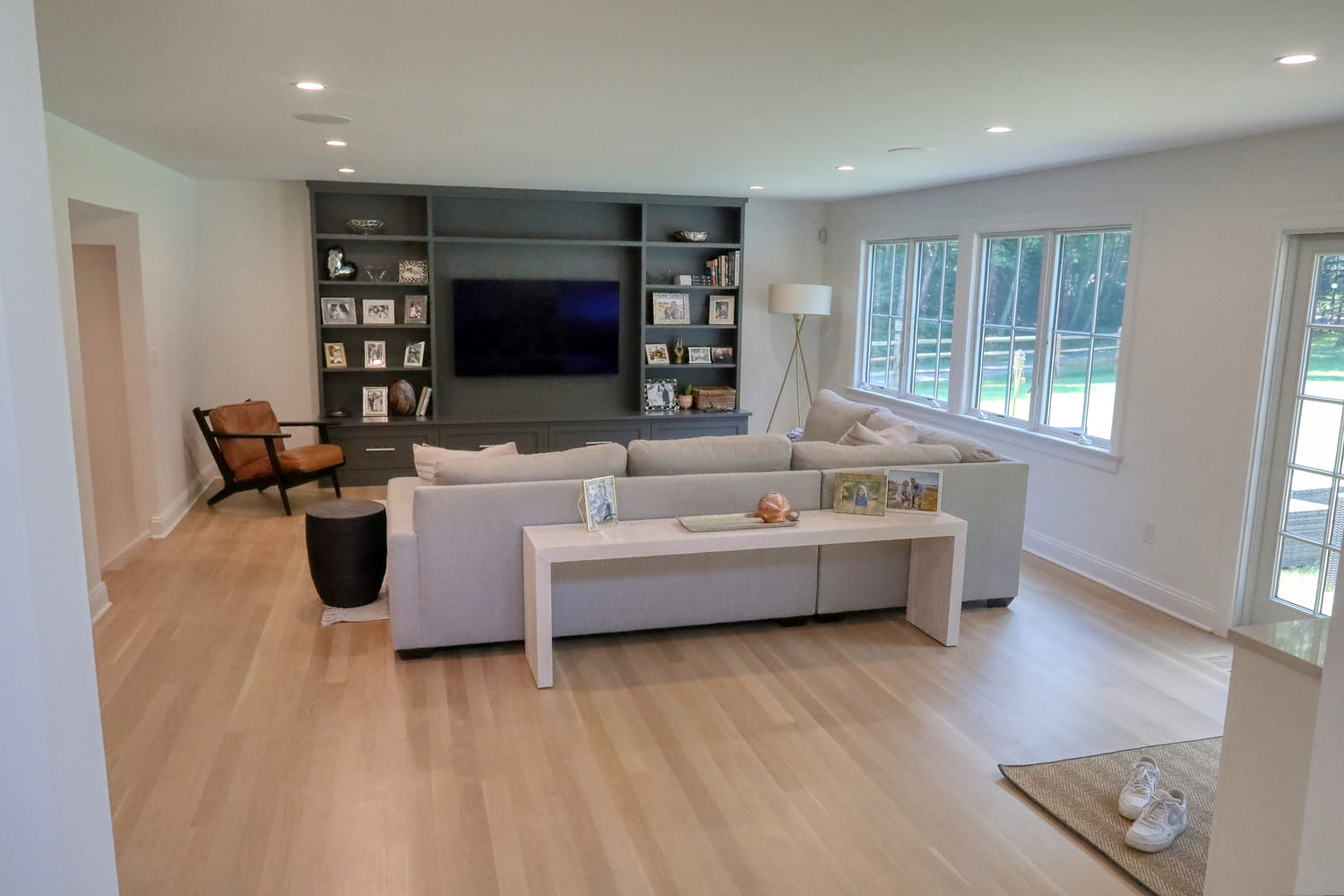 living room with gray built in shelving for entertainment center by raymond design builders in ct