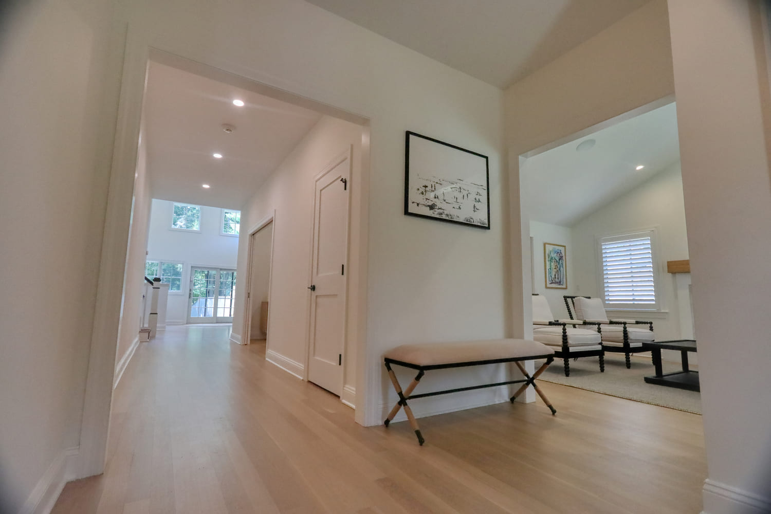 white minimalist foyer with light brown bench and hardwood flooring by raymond design builders in ct