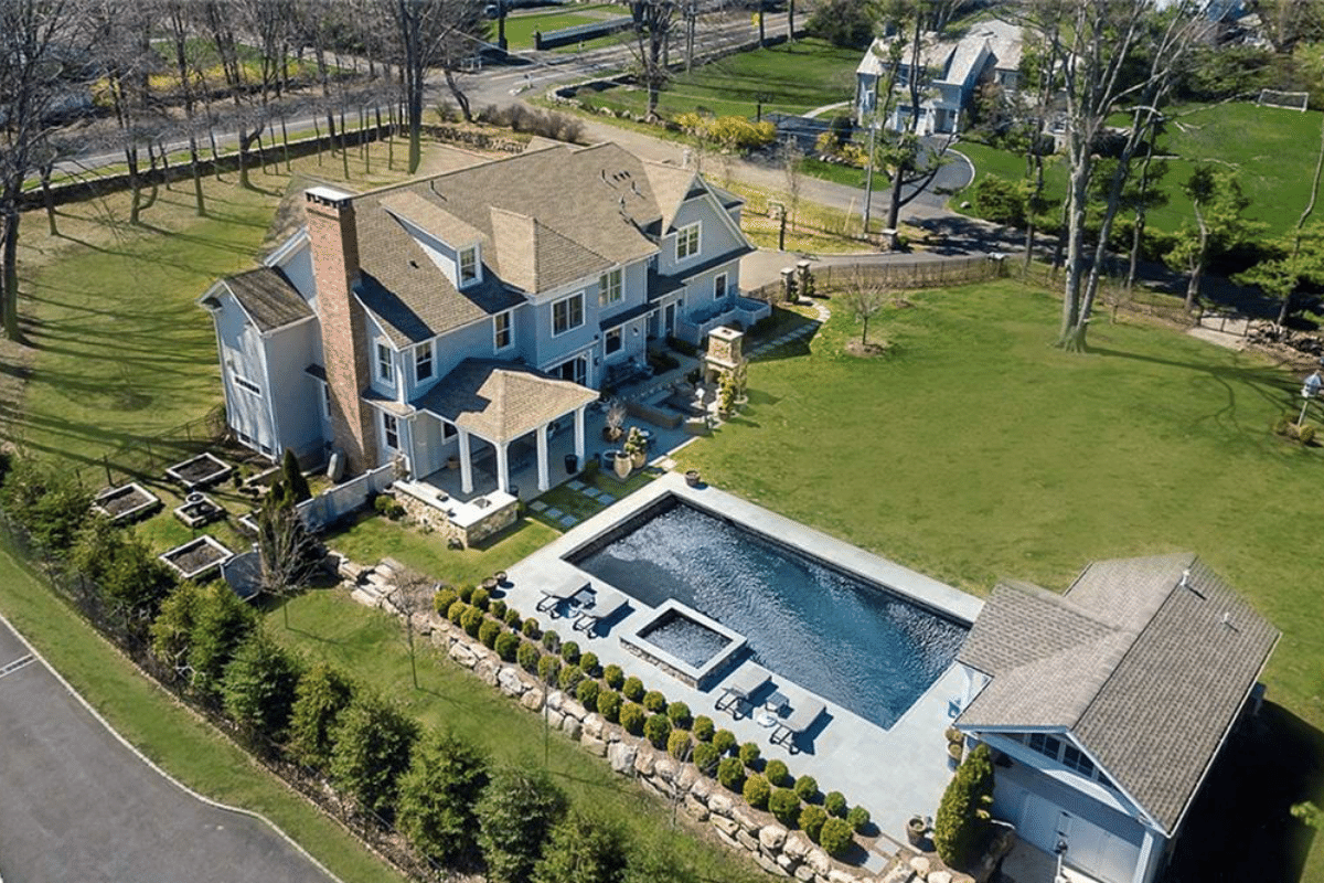 large house with backyard inground pool and pool house by raymond design builders in ct